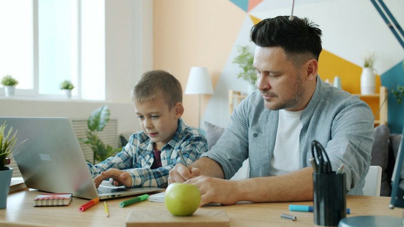 A father and son using a laptop together